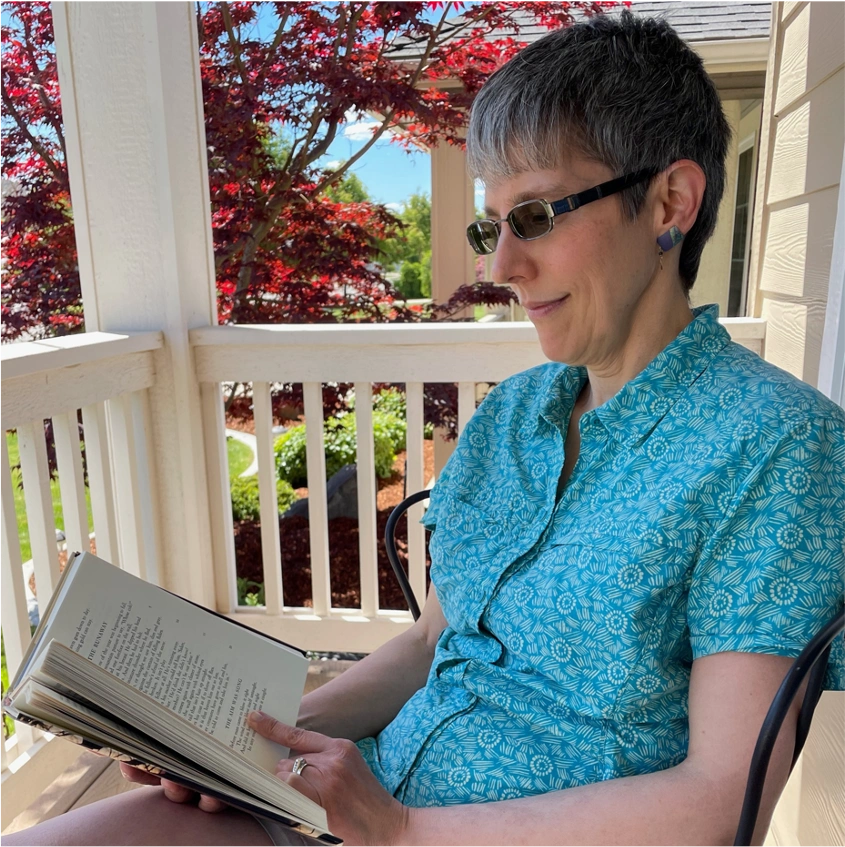 Katrina reading outside on a summer day