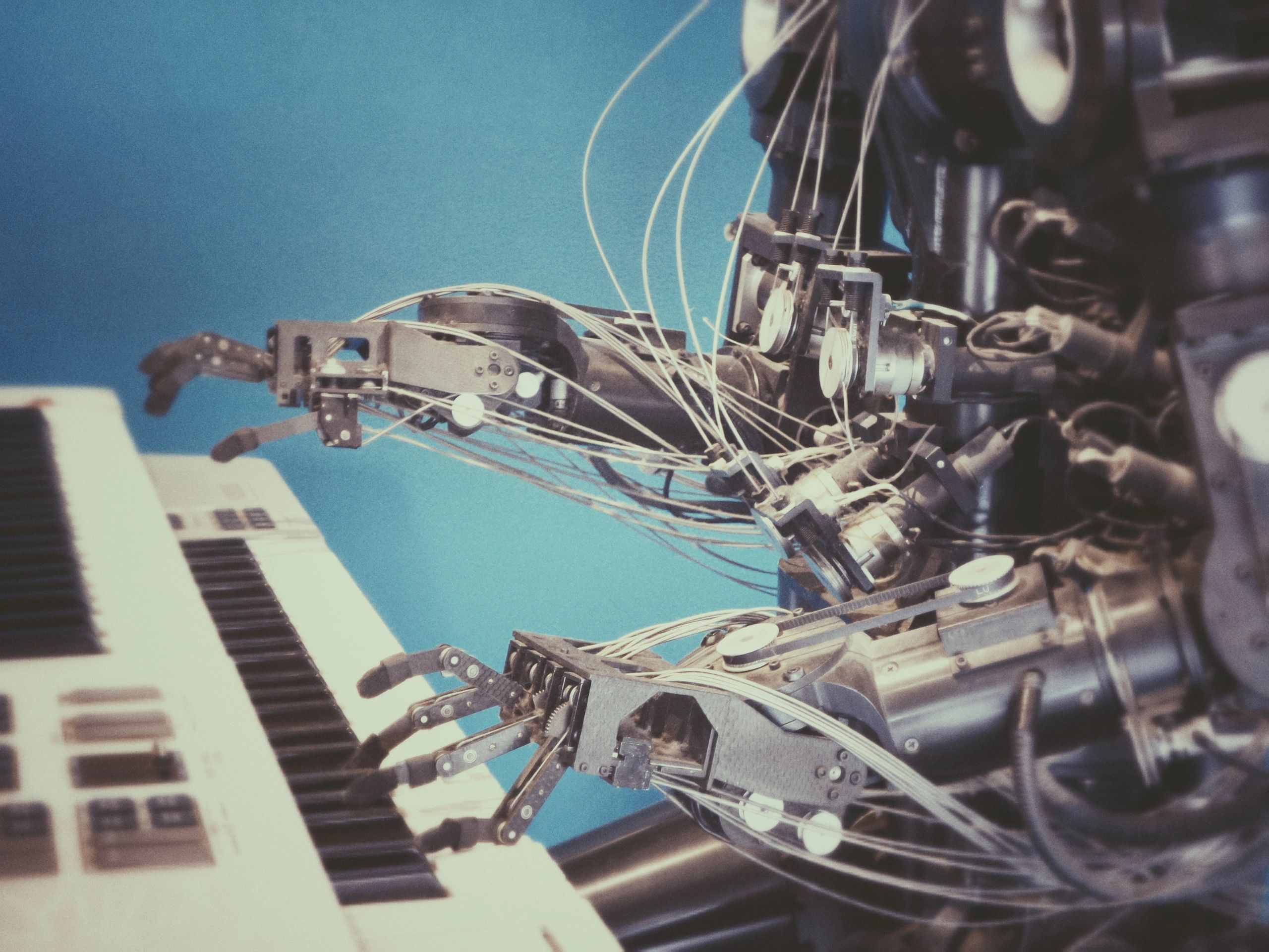 Photo by Possessed Photography on Unsplash - Photo by Possessed Photography on Unsplash - the hands of a robot playing a keyboard using an ML program called an expert system to mimic a human performer