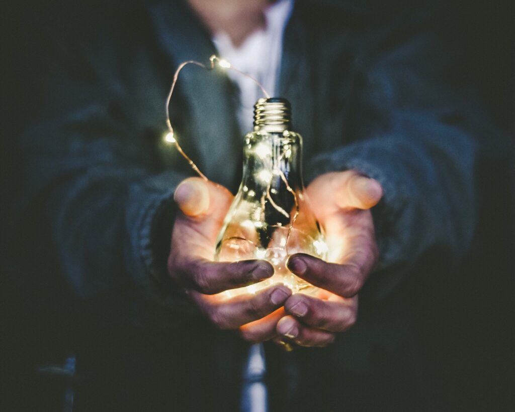 A person holds a light bulb to signify innovation leadership. 