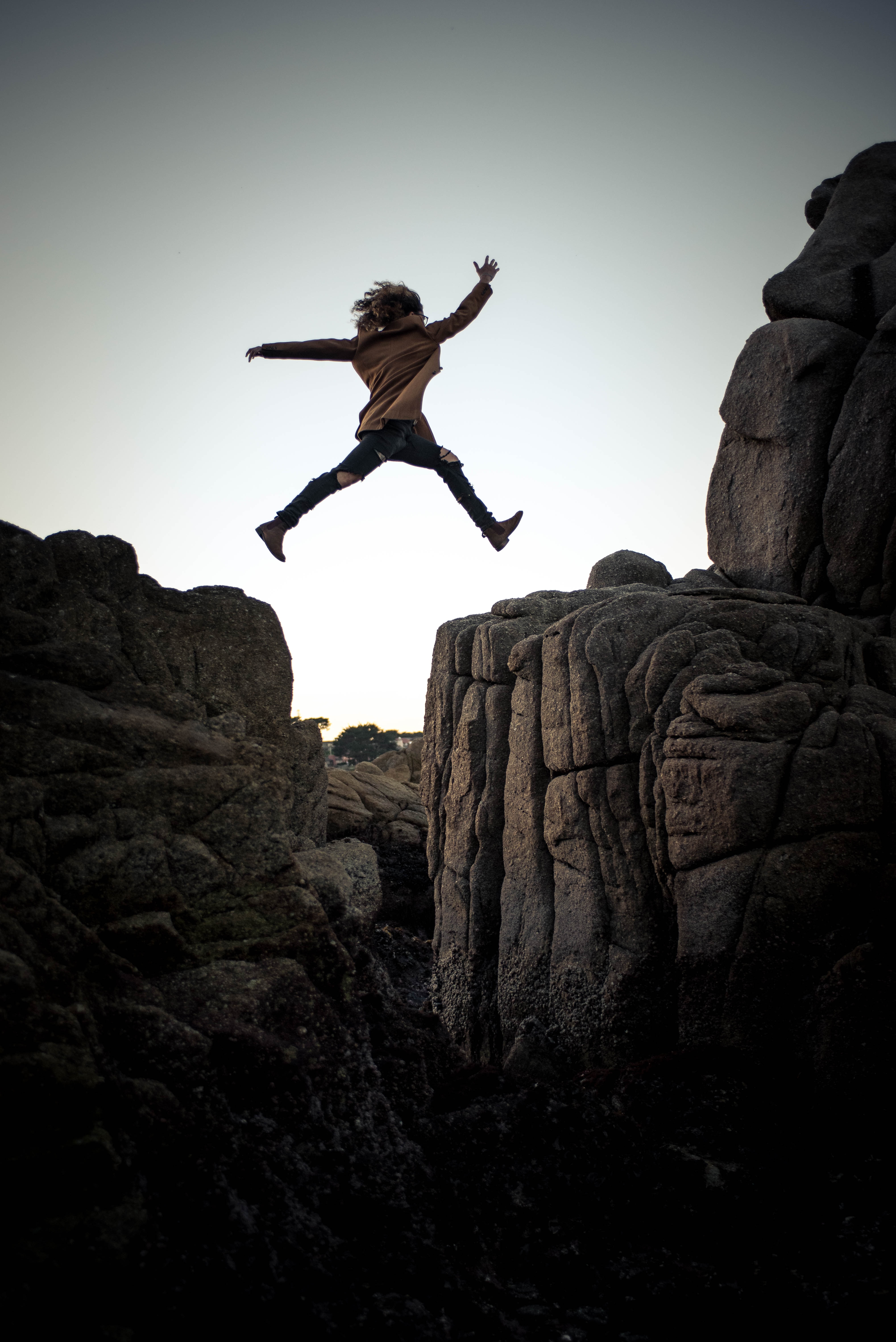 A woman jumps from rock to rock to embody innovation leadership. 