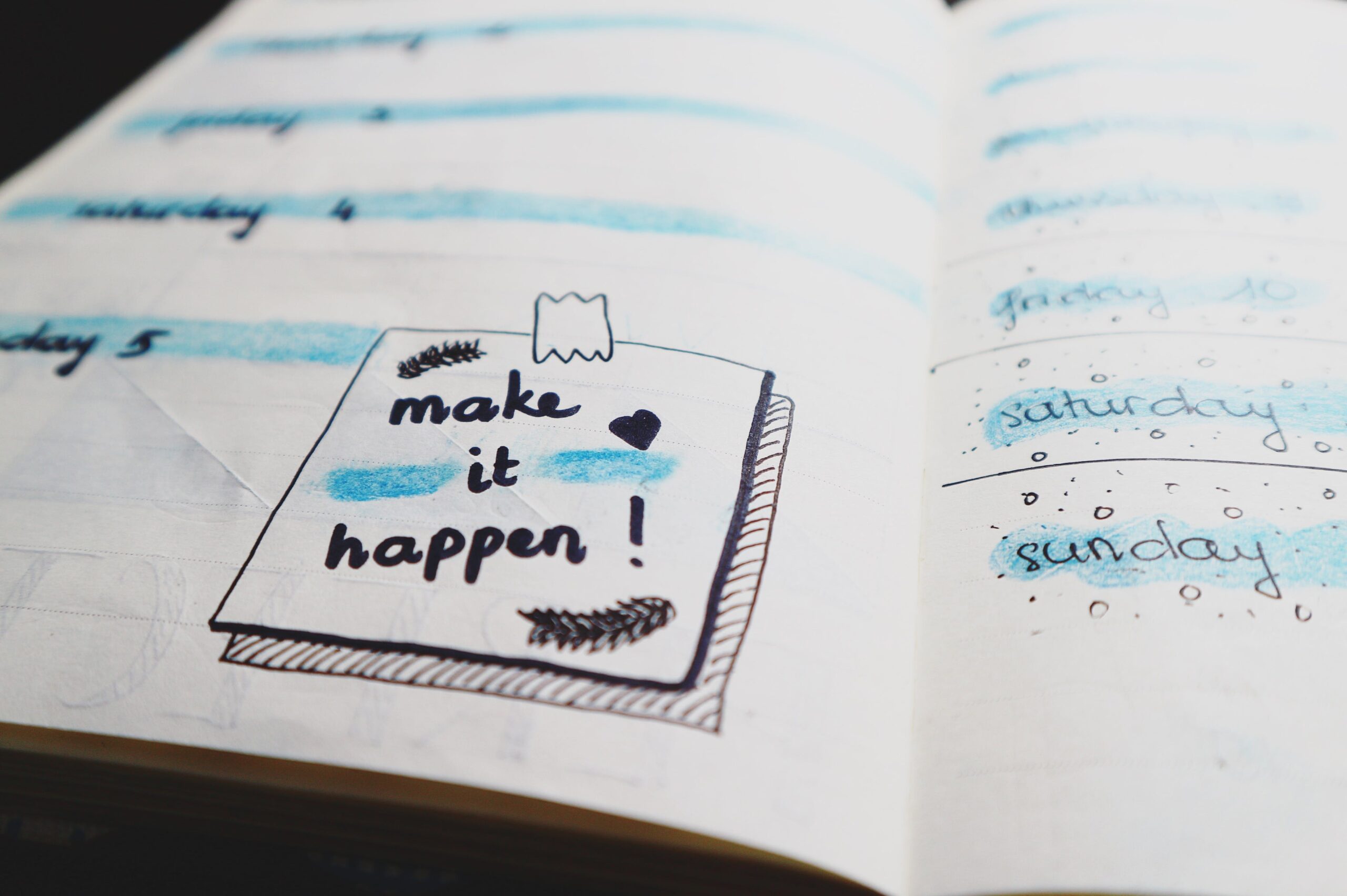 "Make it happen" written on a journal. 