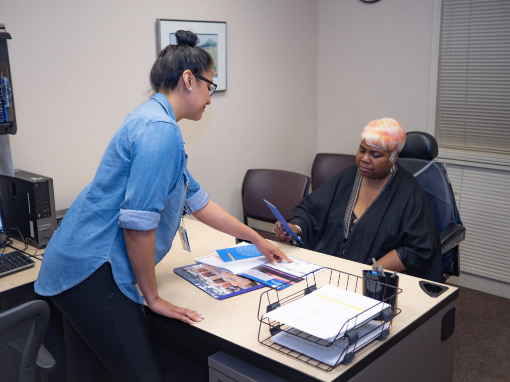 Two women meet in an office discussing a new medicine. 