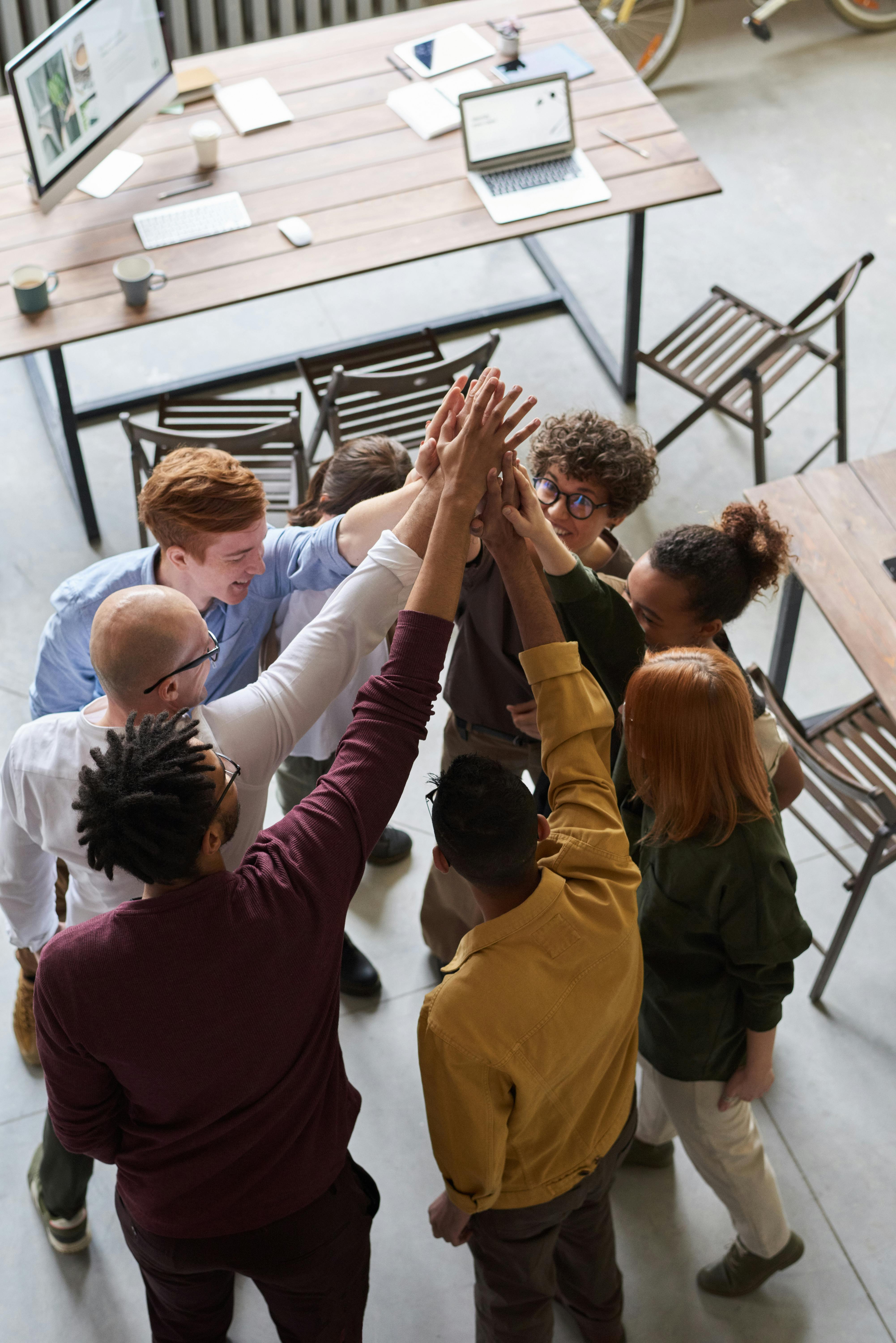 A picture of a group of people giving a high five.