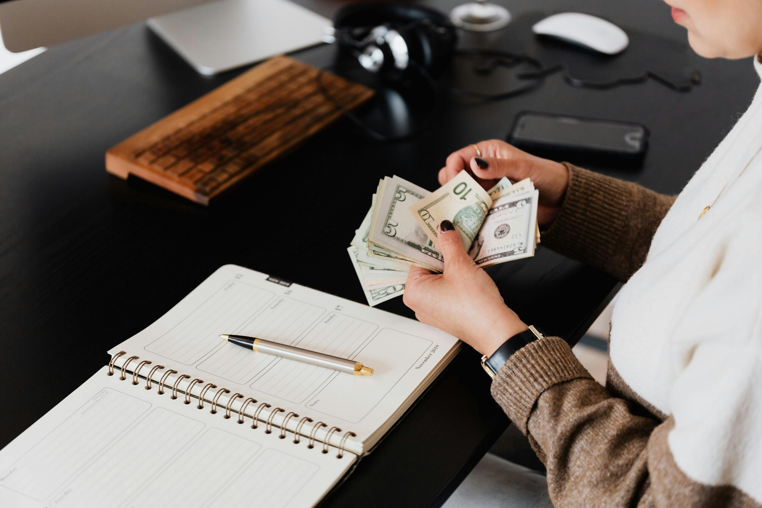 A picture of someone holding US bills, counting them. 